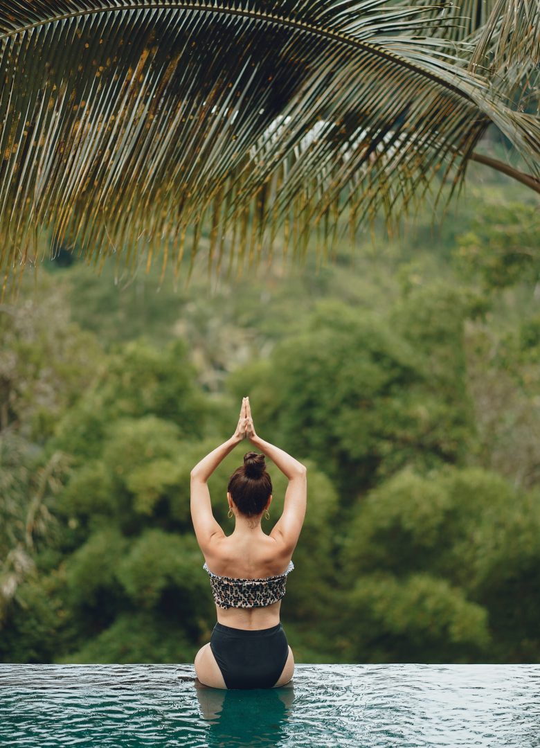 Woman in the swimming pool. Lady in a swimsuit. Girl on a jungle background.
